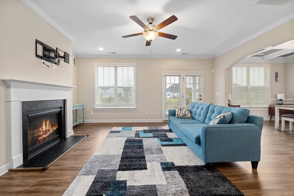 A stylish modern living room featuring a fireplace and blue sofa.
